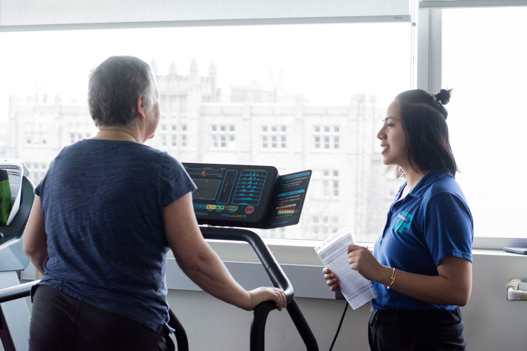 A breast cancer survivor exercising with a Revved Up supervisor