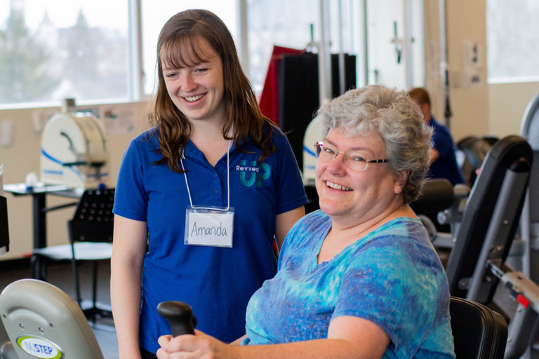 A breast cancer survivor exercising with a Revved Up supervisor