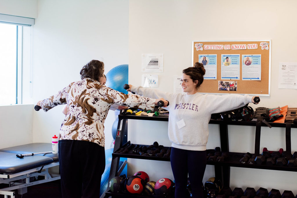 A program member exercising with a student volunteer at Revved Up