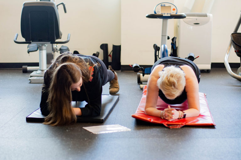 A breast cancer survivor exercising with a Revved Up volunteer