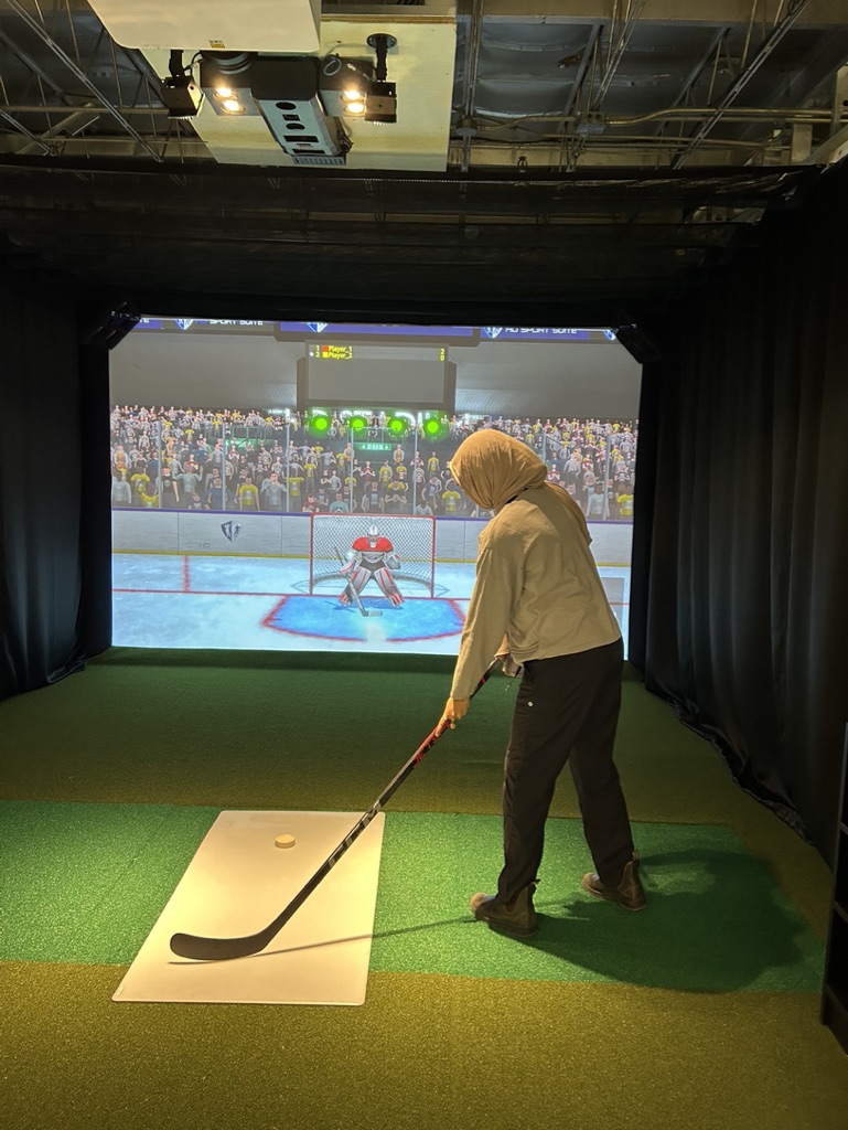 Zainab showing off her slapshot on the indoor sports simulator!