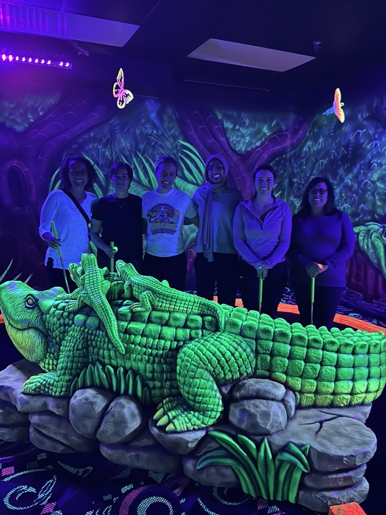 Lab group smiling on the indoor mini putt course